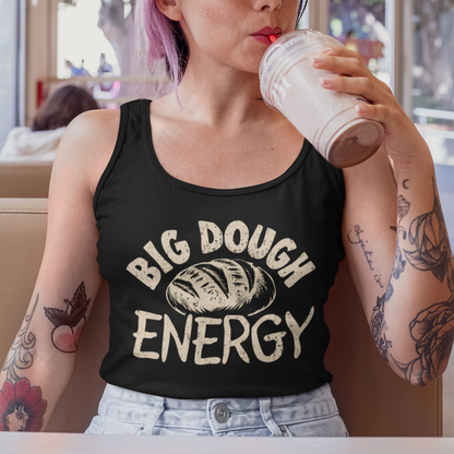 Person wearing a black tank top with 'Big Dough Energy' text, drinking from a paper cup in a casual setting.