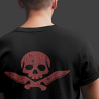Person wearing a black t-shirt with a red skull and crossbones design on the back against a dark background