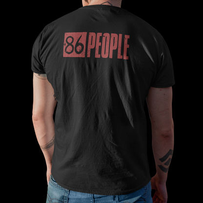 A man viewed from behind wearing a black t-shirt with a red graphic print that reads '86 PEOPLE' on the back, paired with blue jeans against a solid black background.