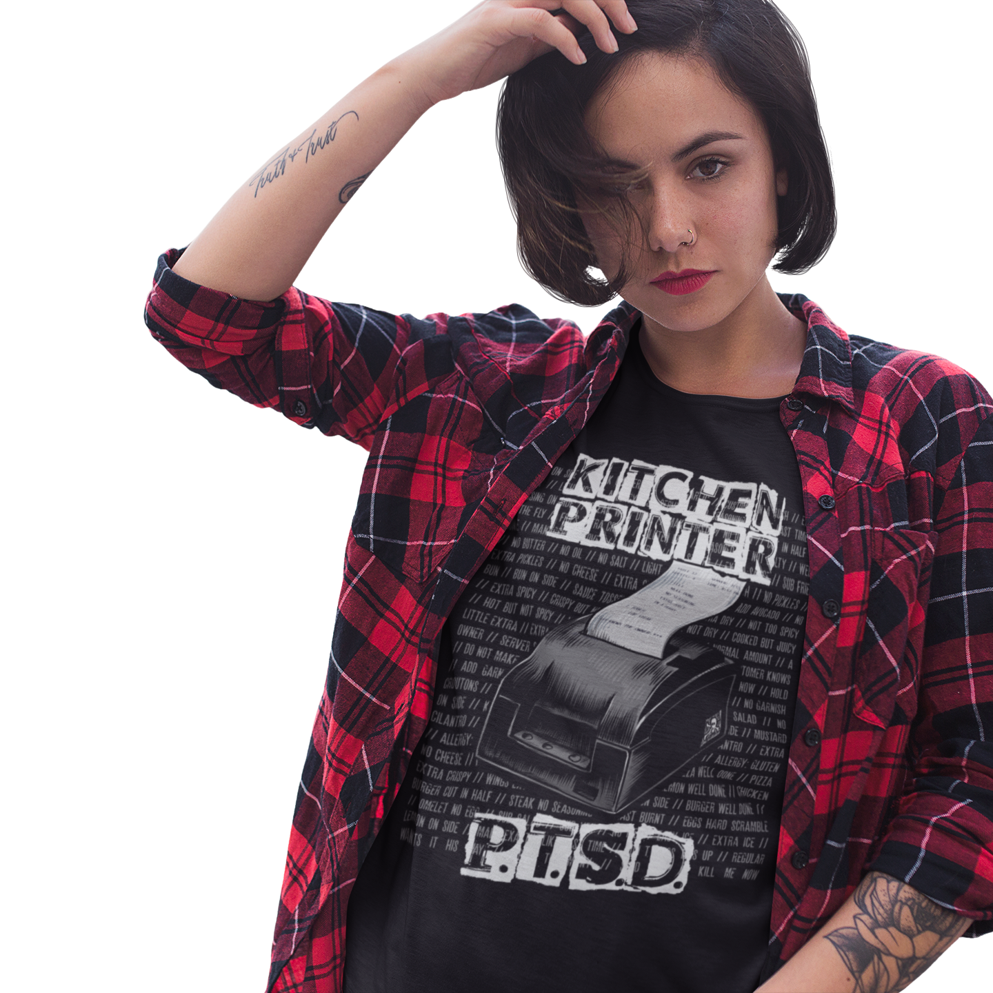 Person wearing a black graphic t-shirt with text and a red and black plaid shirt on a white background
