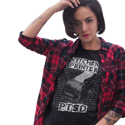 Person wearing a black graphic t-shirt with text and a red and black plaid shirt on a white background