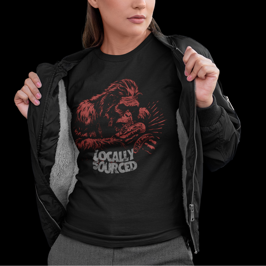 Woman wearing a black t-shirt with red graphic and text, standing against a black background