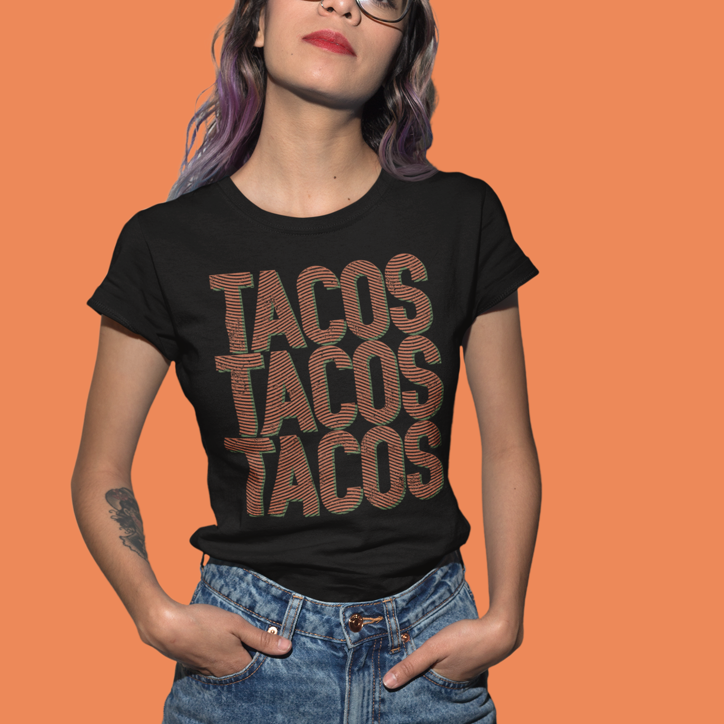 Person wearing a black t-shirt with 'TACOS TACOS TACOS' text on an orange background