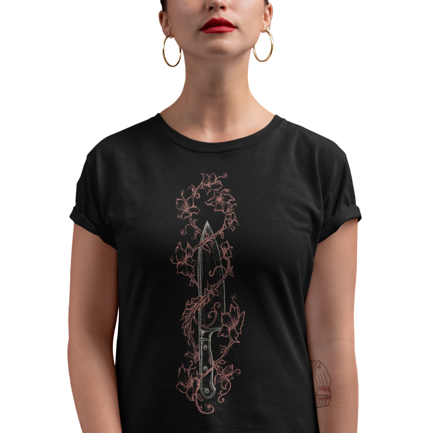 A woman wearing a black short-sleeve t-shirt with a vertical graphic of a dagger wrapped in a rose-gold ornate vine design, set against a plain white background.