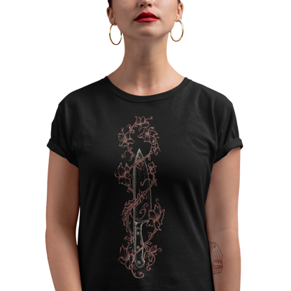 A woman wearing a black short-sleeve t-shirt with a vertical graphic of a dagger wrapped in a rose-gold ornate vine design, set against a plain white background.